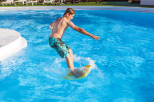 boy has fun jumping in the pool