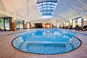 An indoor mosaic pool with intricate and artistic tilework on its interior surface, adding a touch of elegance and visual appeal to the enclosed aquatic space.