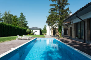 A rectangular pool surrounded by trees and houses, offering a suburban or residential setting with a combination of natural and architectural elements.