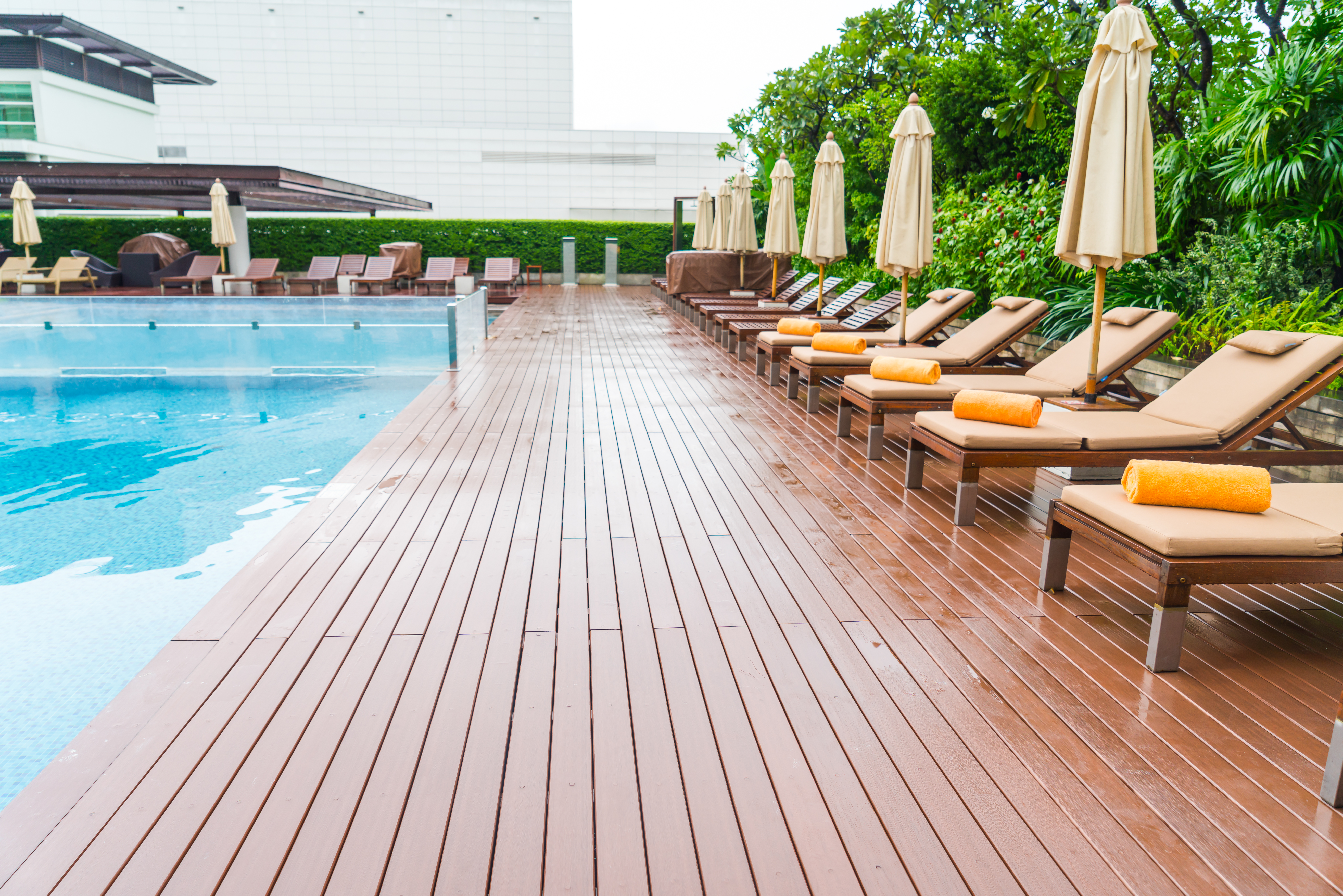 Wooden benches by the poolside, providing comfortable seating for pool-goers to relax and enjoy the outdoor atmosphere.