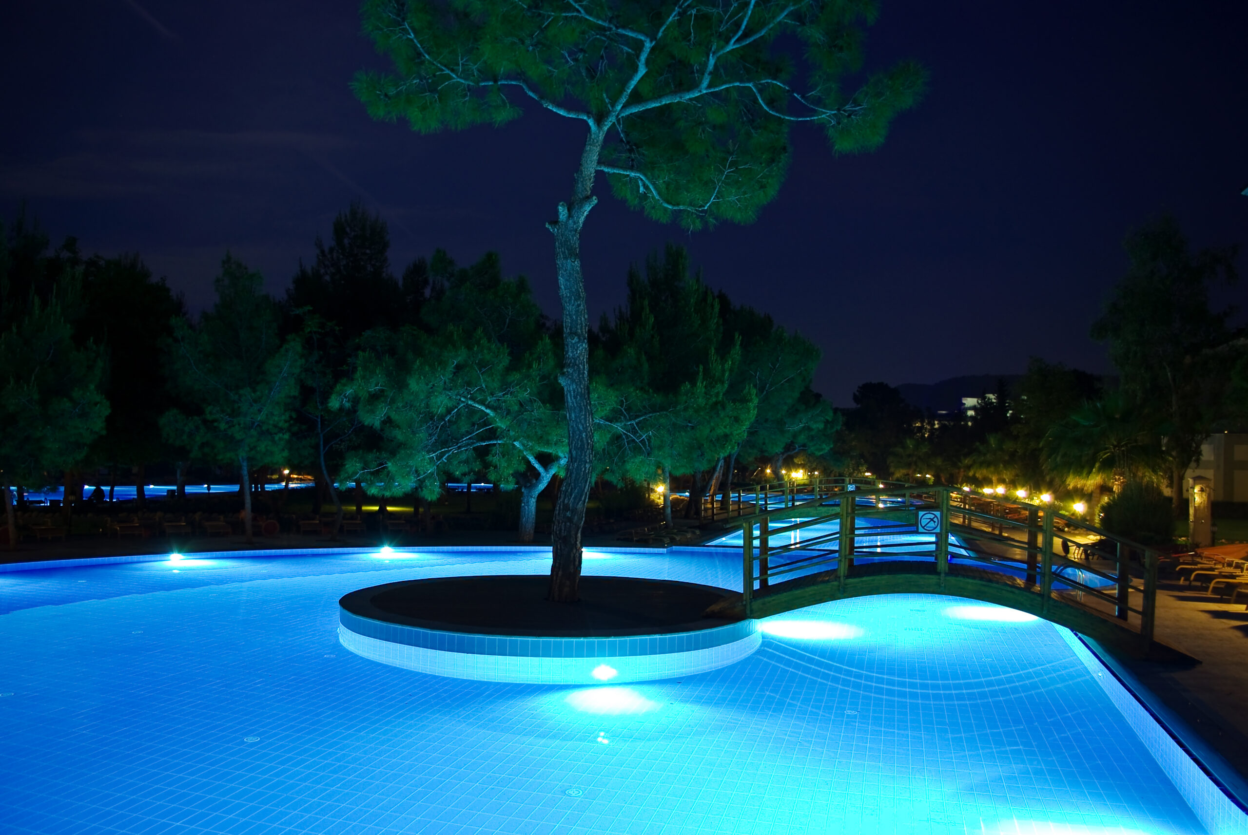 A pool bridge illuminated by lights at night