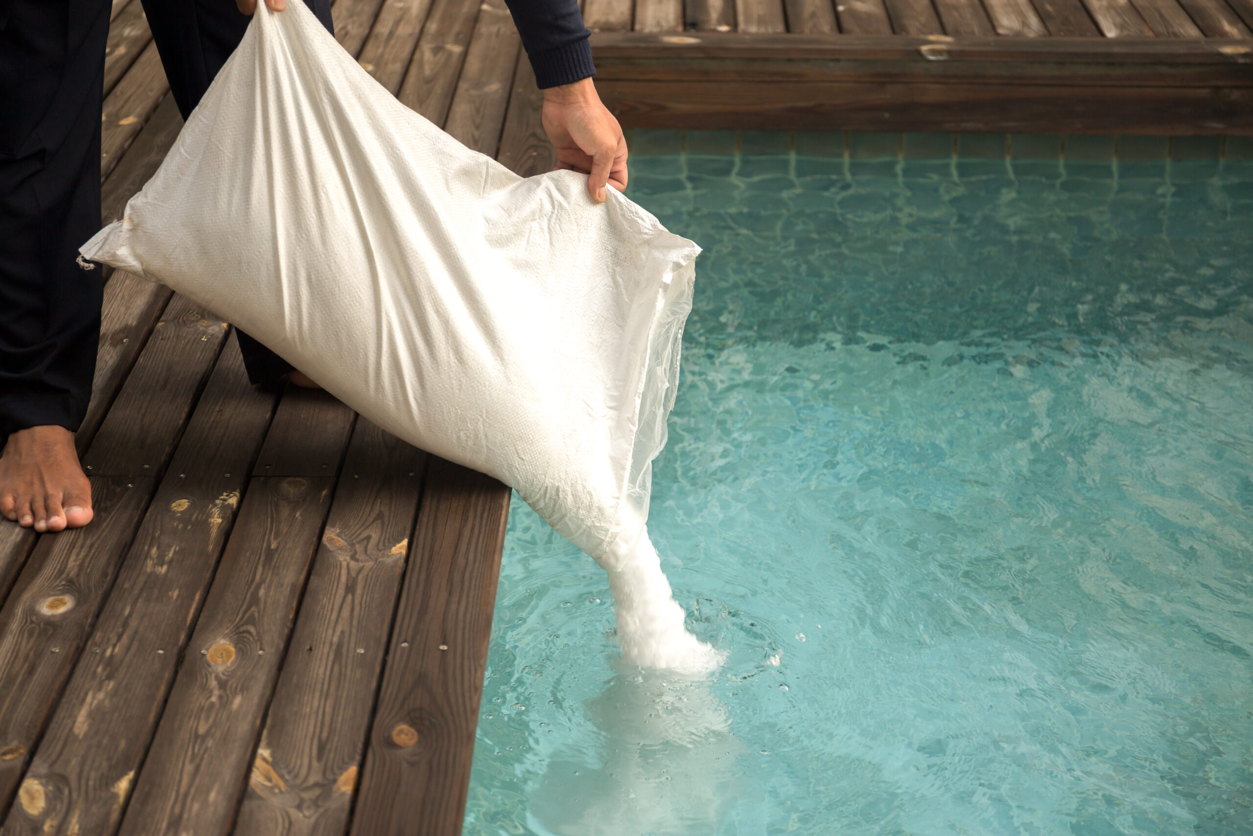 Adding chlorine to a pool, a common maintenance practice to sanitize the water