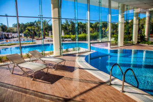 Sunbeds in the indoor swimming pool with views of the outdoor pool