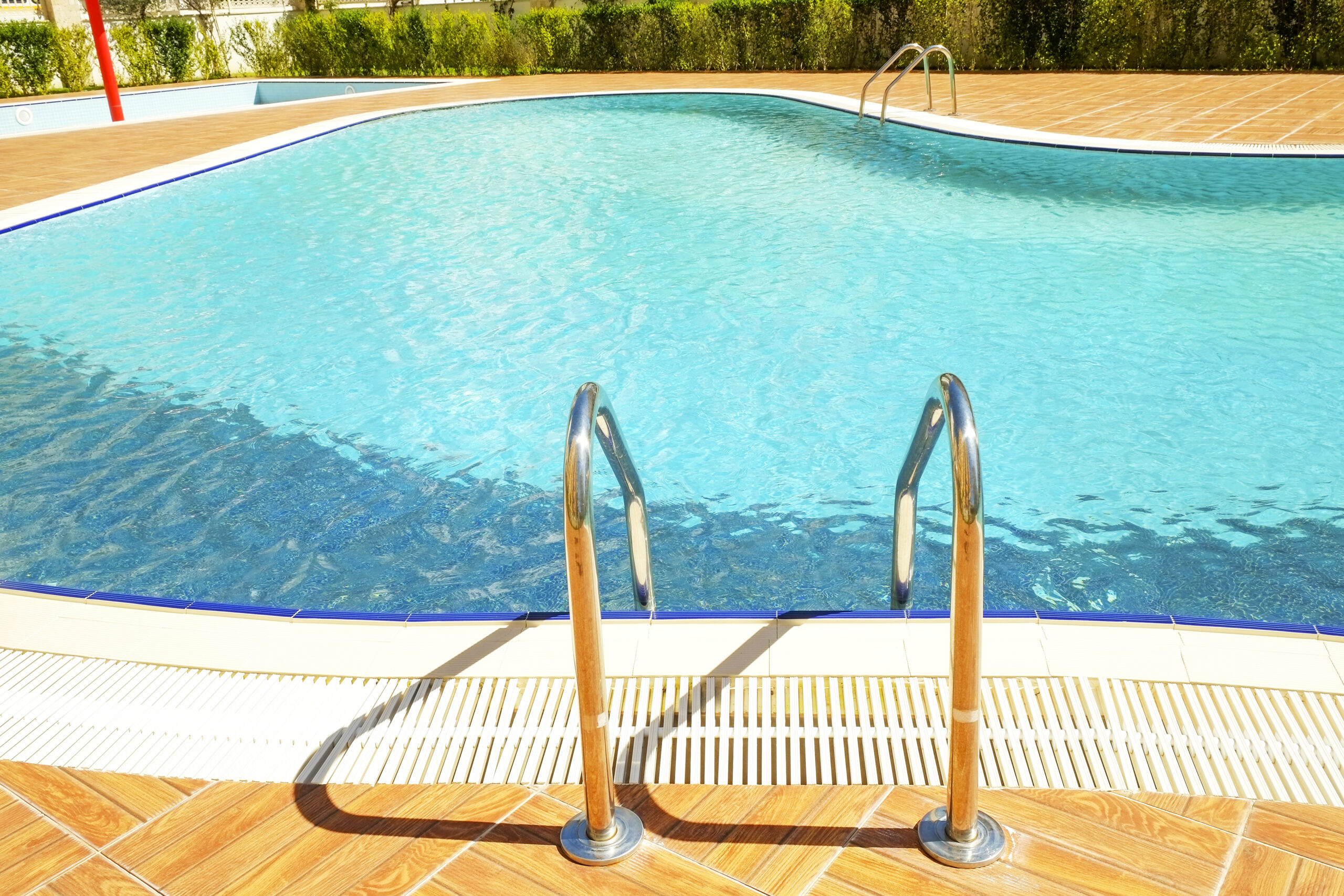 Channel drains surrounding a pool to efficiently manage water runoff and drainage