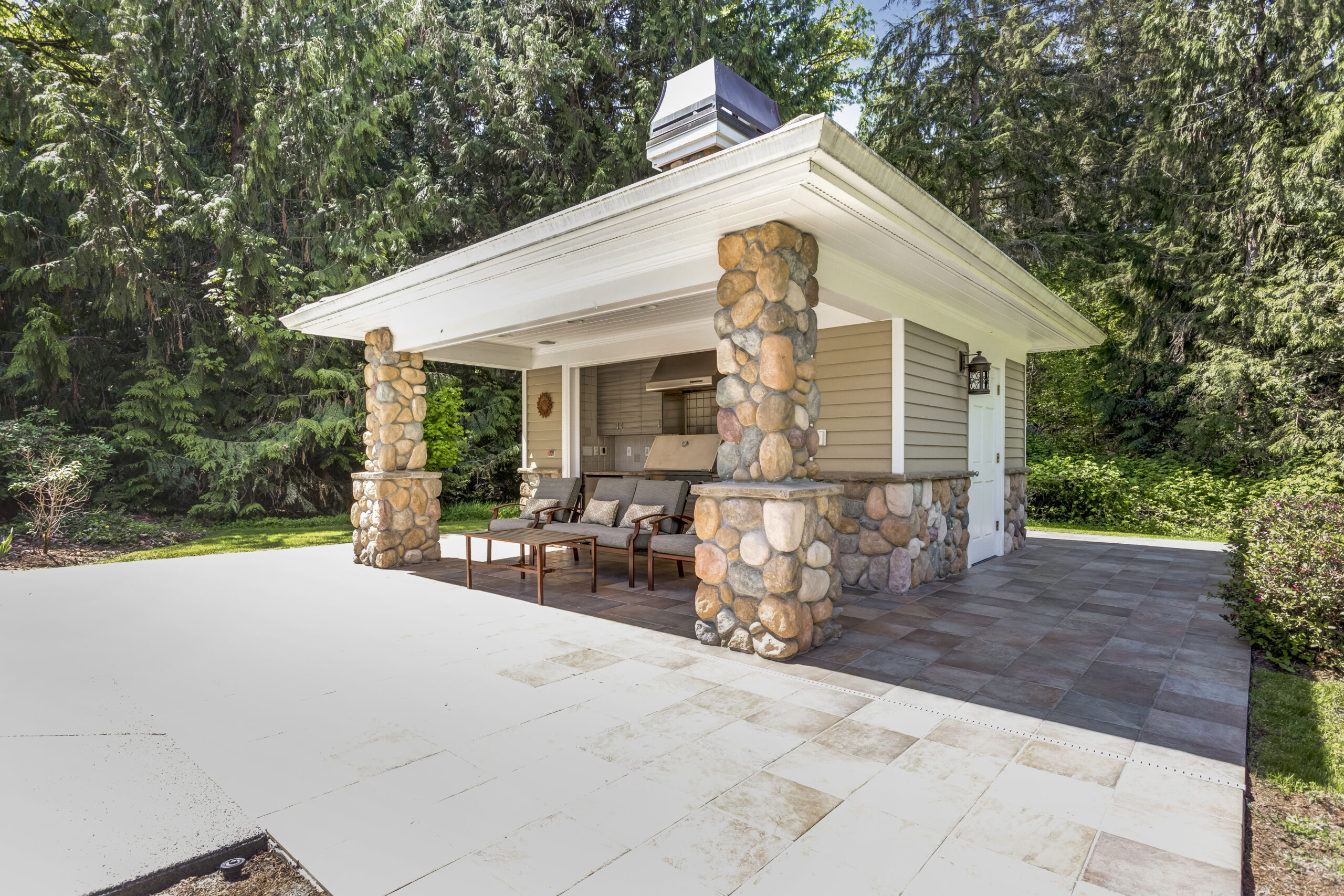 An outdoor kitchen adjacent to a pool