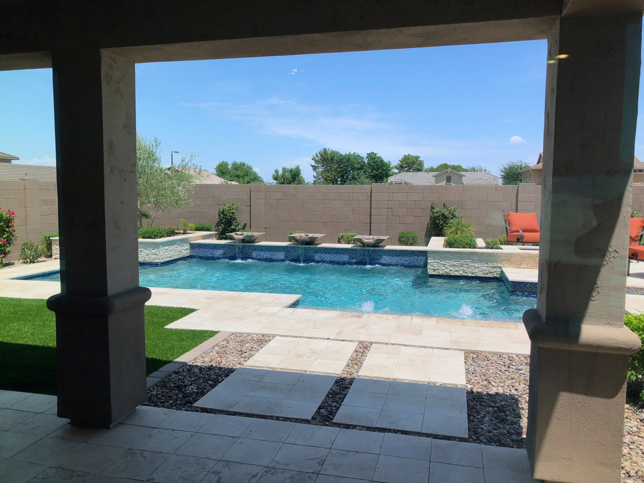 A pool with shades at the side, providing sun protection and a shaded area for relaxation by the water.