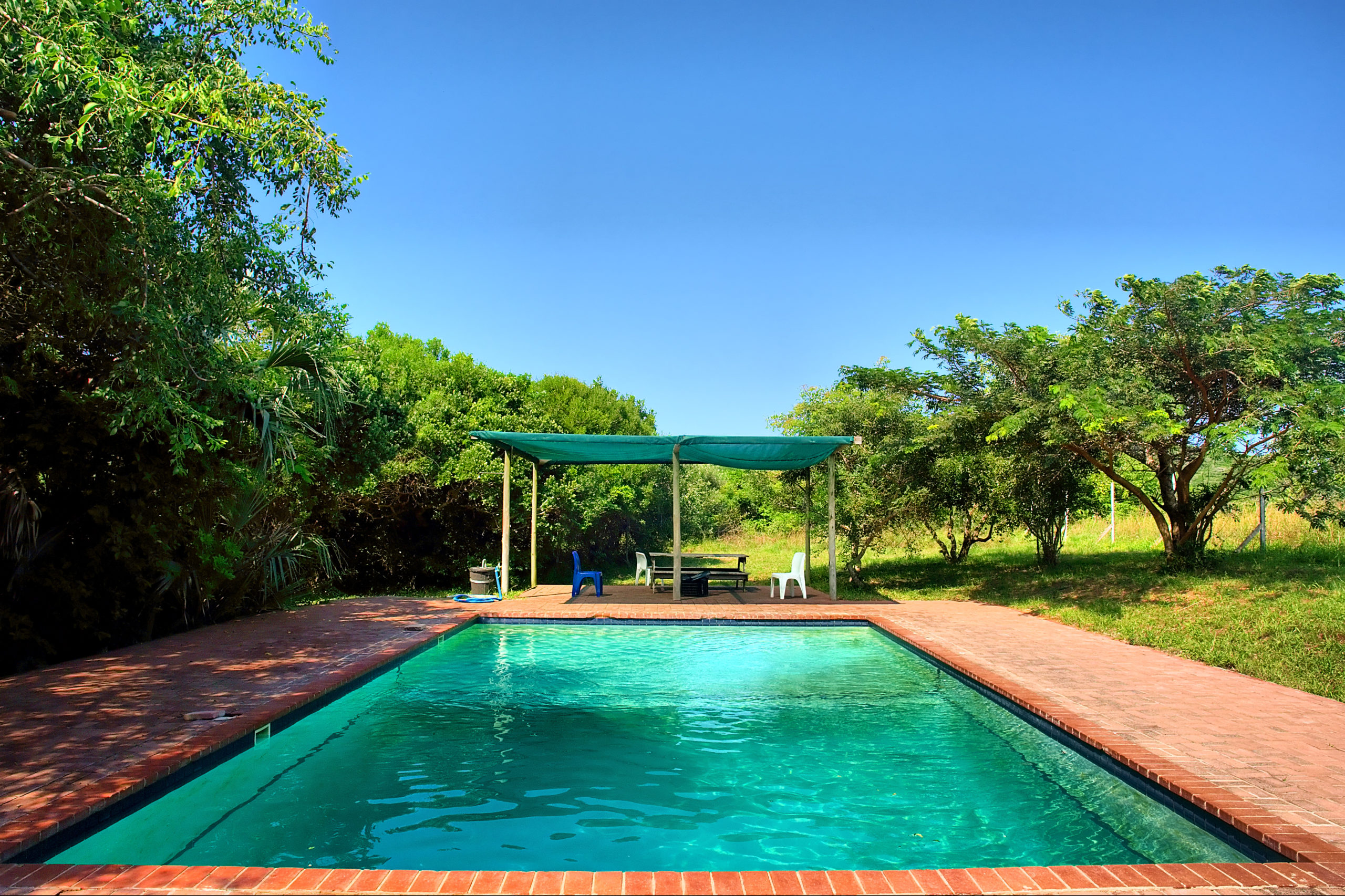 Crystal-clear blue water in an outdoor pool, reflecting the vibrant blue sky and creating an inviting and refreshing swimming environment.