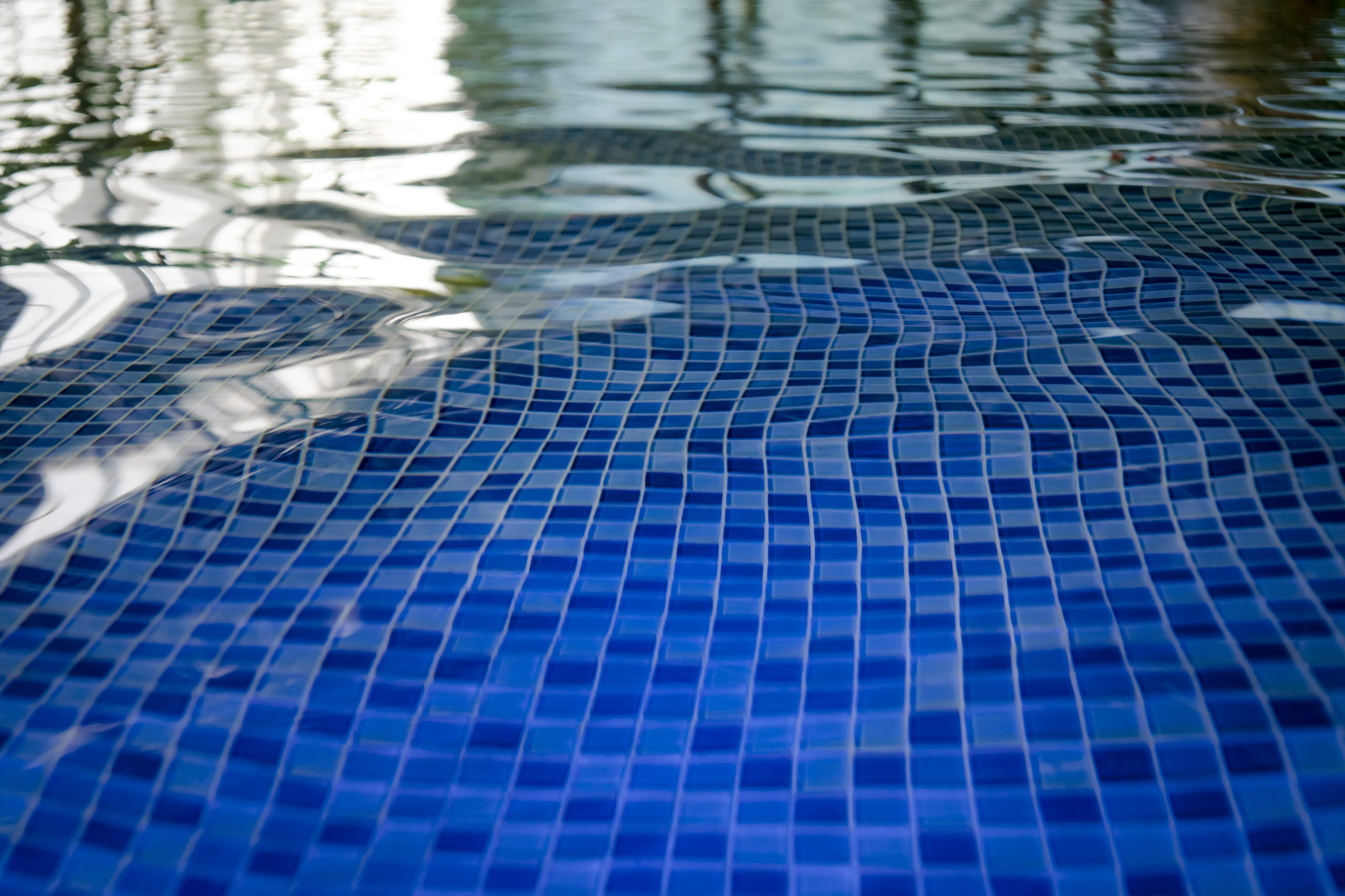 "Pool tiles reflecting the shimmering water, adding to the aesthetic appeal of the pool."