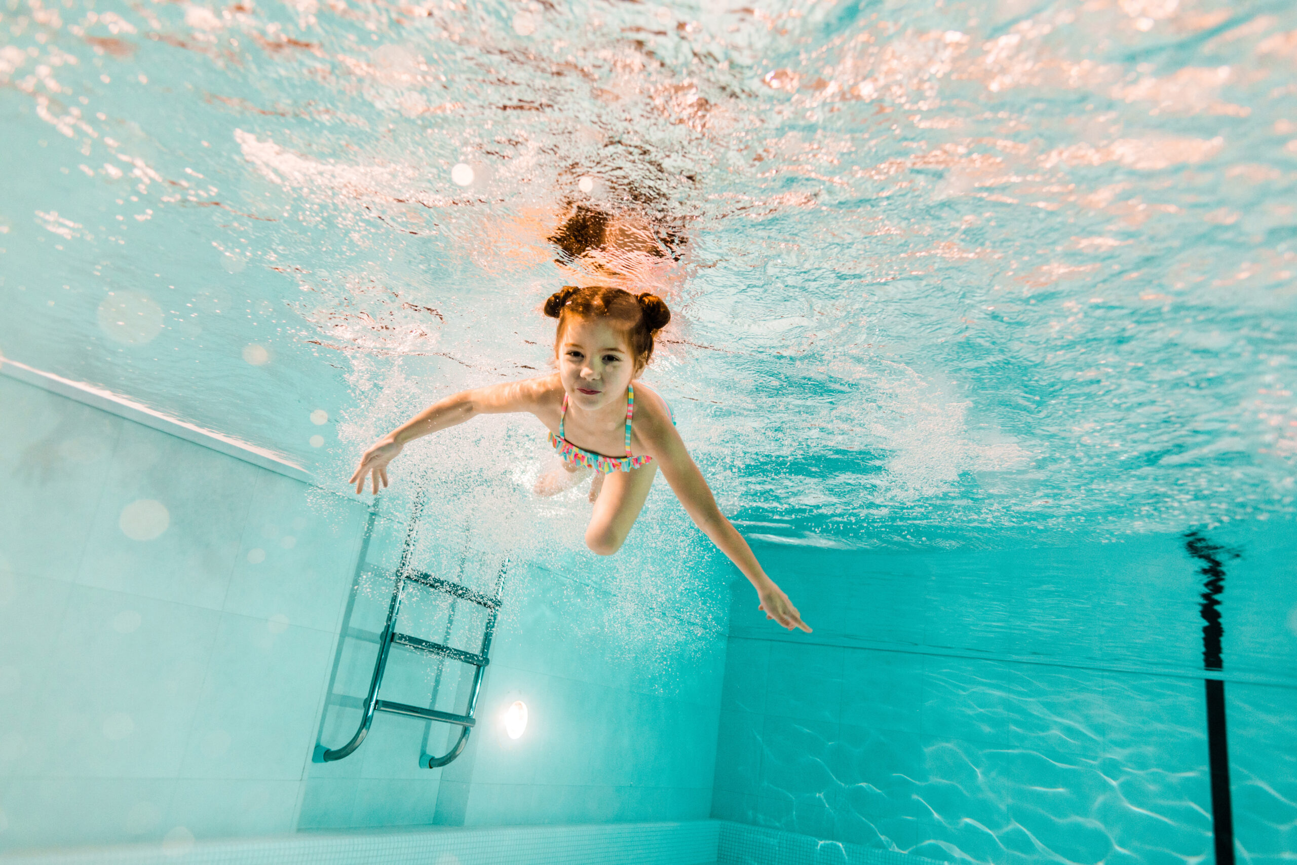 A child diving into the water, demonstrating a joyful and playful leap into the pool.