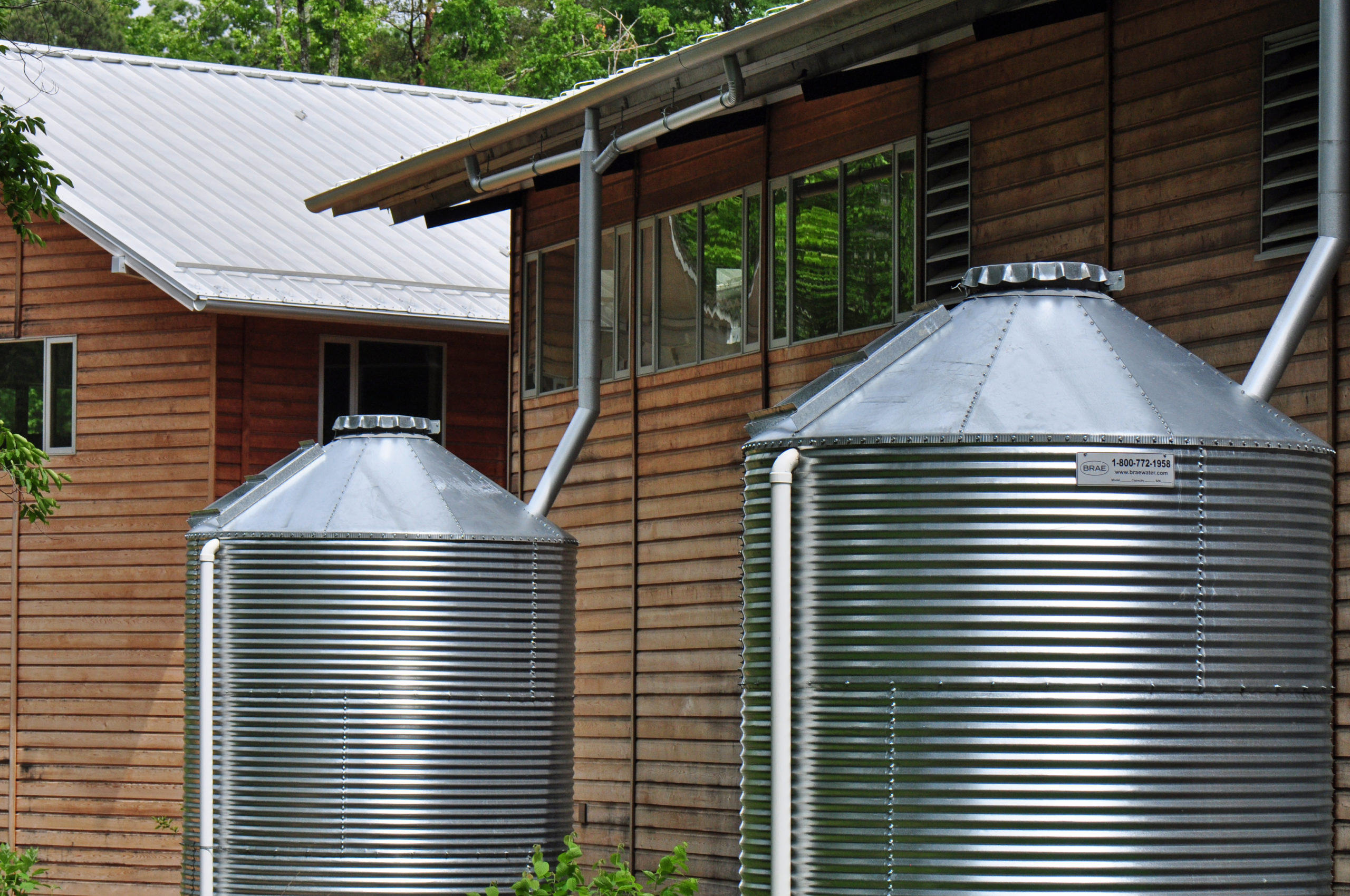A rainwater drum collection system, consisting of large barrels or containers designed to capture and store rainwater for various eco-friendly purposes such as irrigation and conservation.