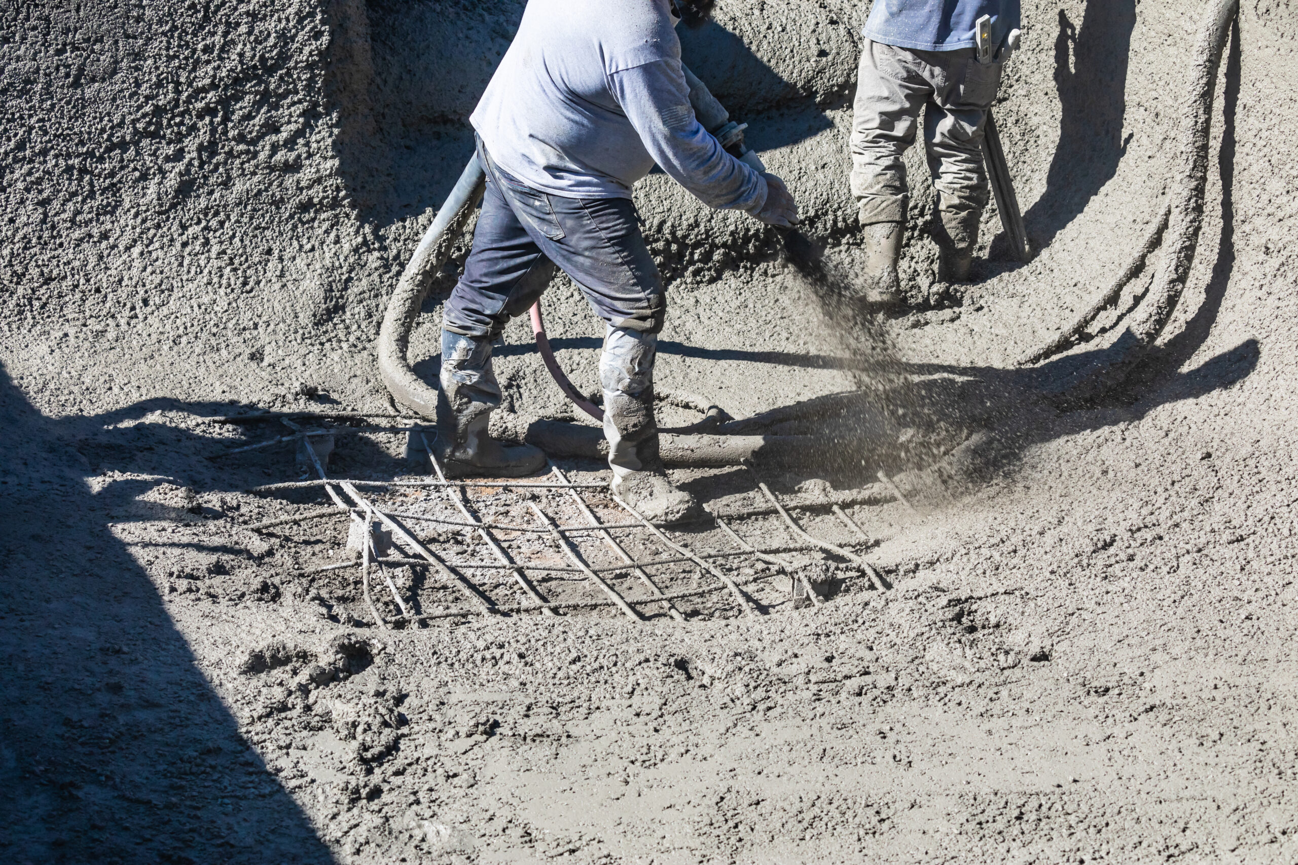 Pool Construction Worker Shooting Concrete, Shotcrete or Gunite Through Hose