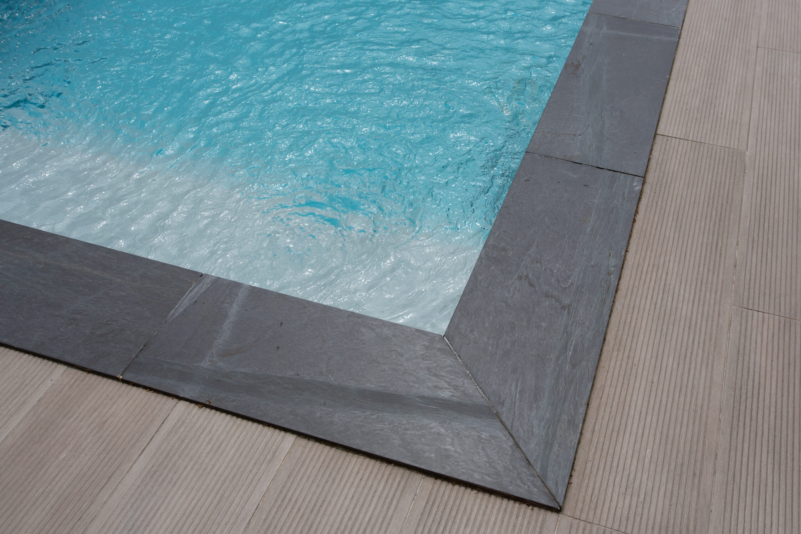 Installed coping for a pool, the protective and decorative edge material around the pool's perimeter.