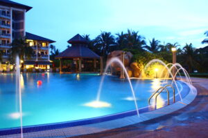 A pool illuminated by colorful lightings and featuring fountains in action, creating a captivating and visually dynamic aquatic display.