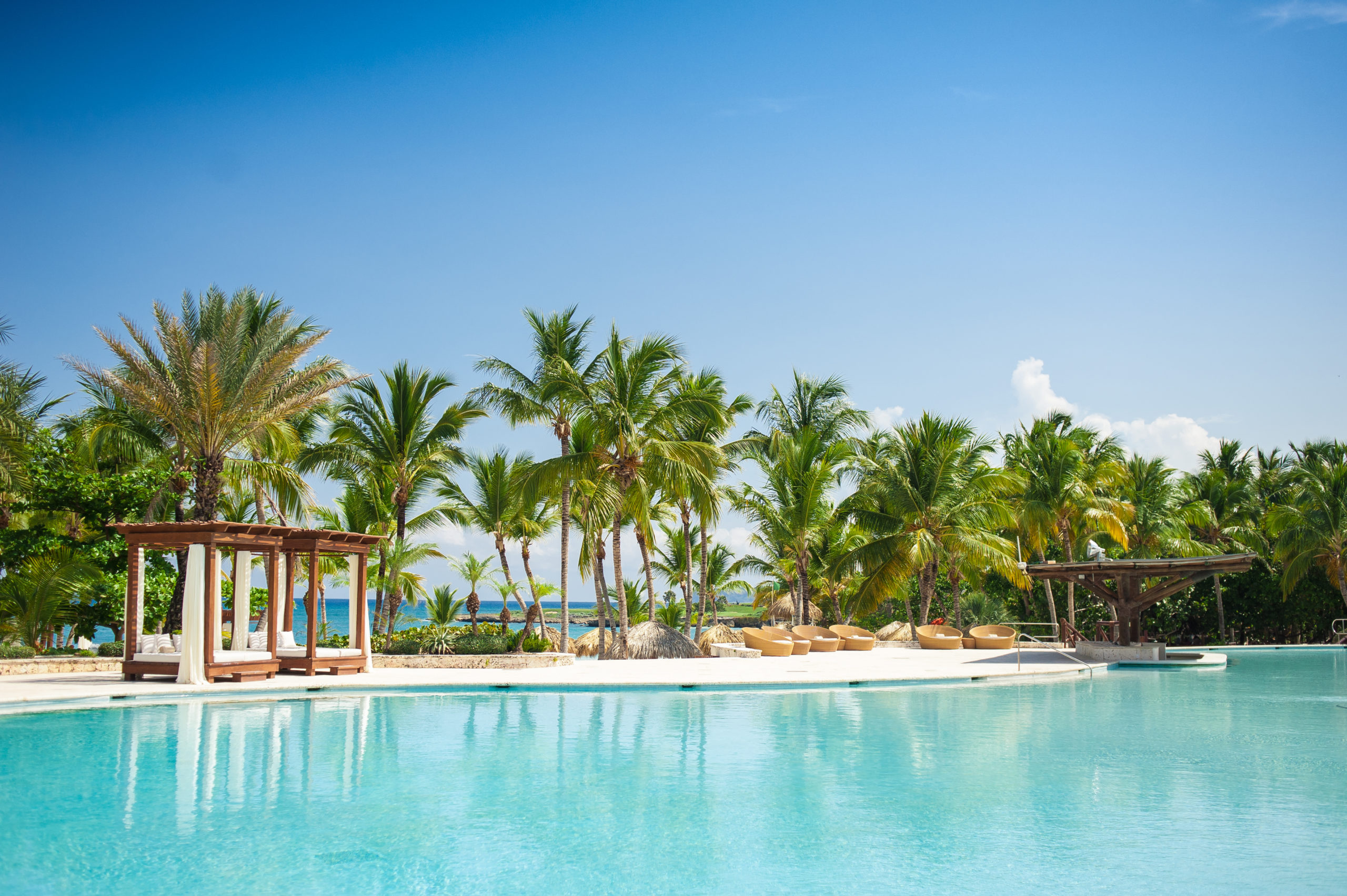 A scenic view of a pool surrounded by lush trees and featuring a charming poolside mini house, providing an idyllic spot for relaxation and enjoyment.