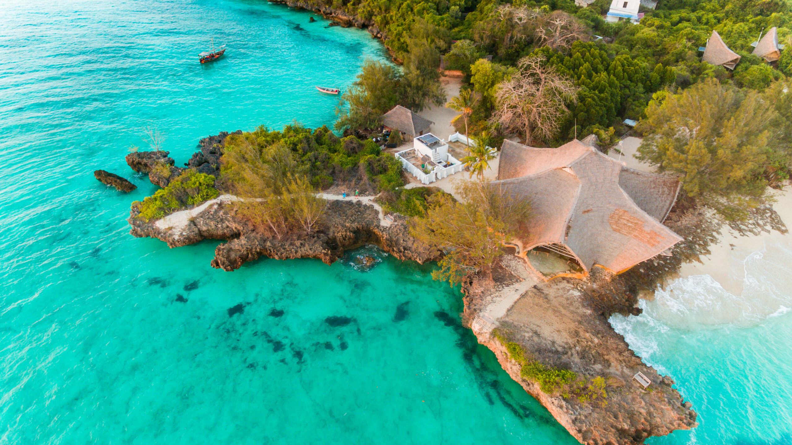 A naturally designed lagoon pool, blending seamlessly with its surrounding landscape, featuring curvaceous shorelines, sandy beaches, and lush vegetation for a tranquil and organic swimming experience.