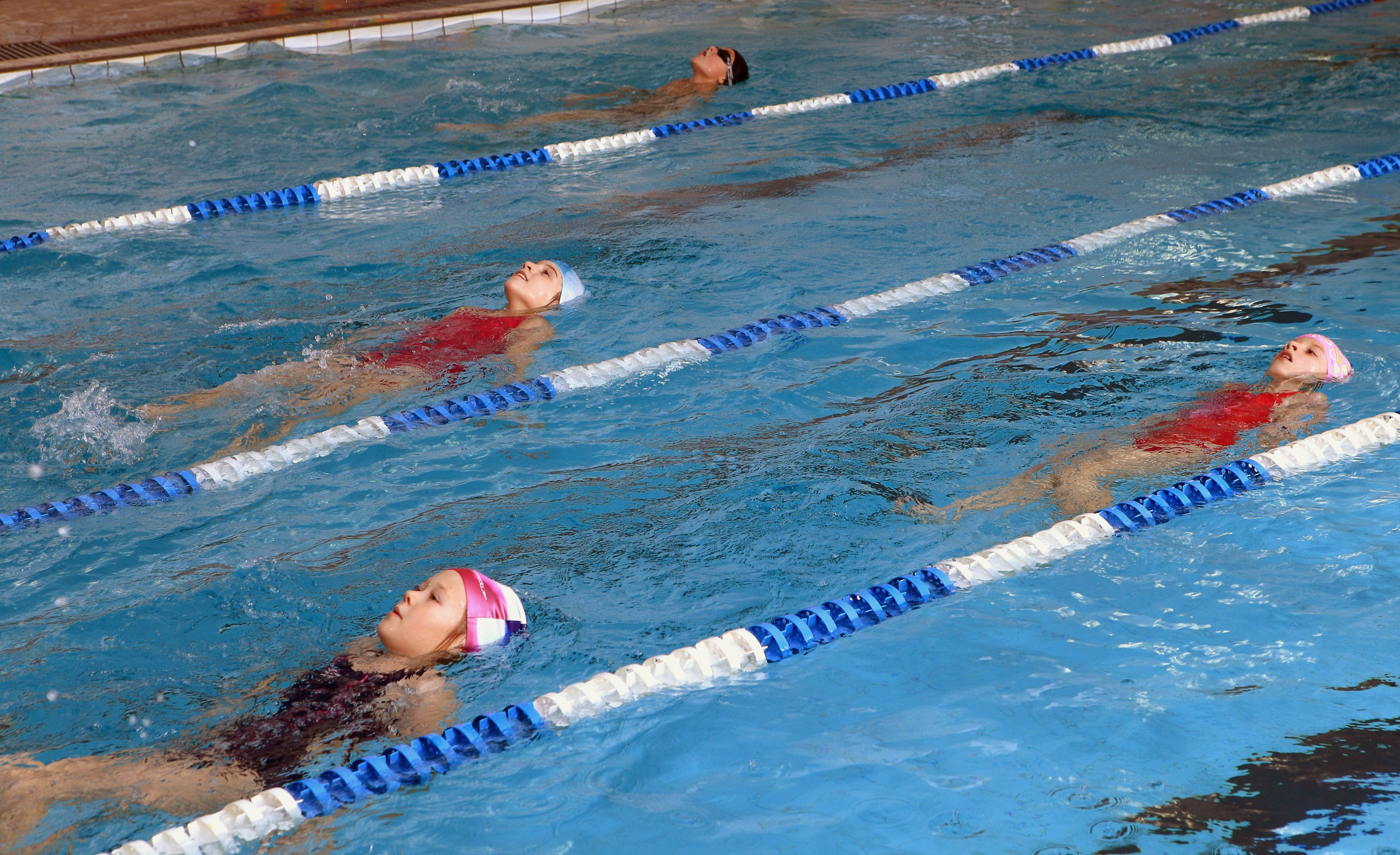 Children floating in a lap pool, enjoying a buoyant and playful swimming experience.