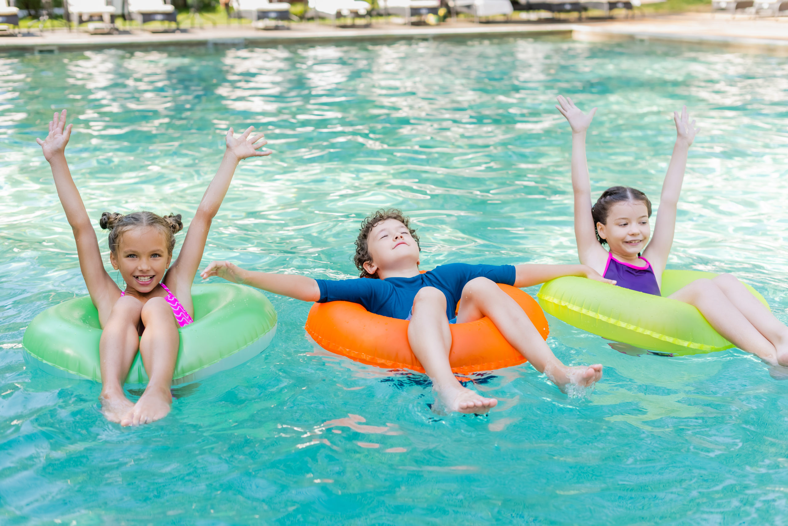 Children safely using lifebuoys at the pool, demonstrating water safety awareness and precautions.