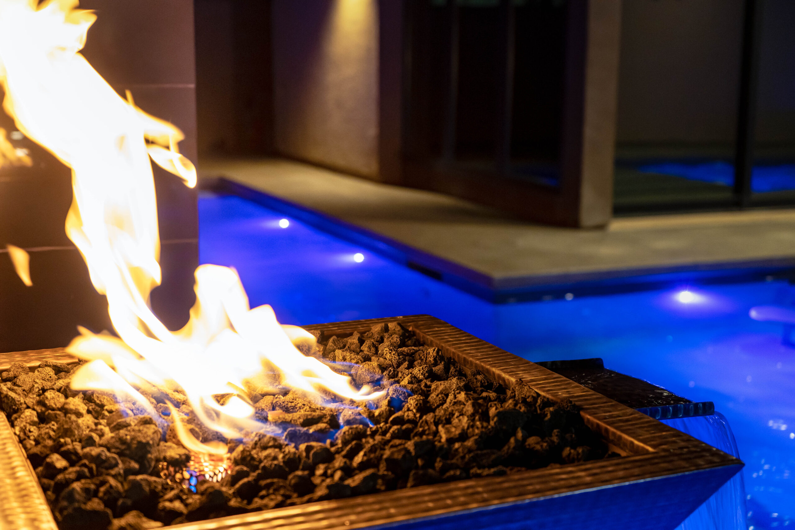 A controlled and safe fire feature integrated into a pool area