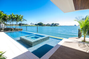 Miami Beach - April 2020: Luxury infinity pool and jacuzzi by a waterfront. Contemporary South Florida design.
