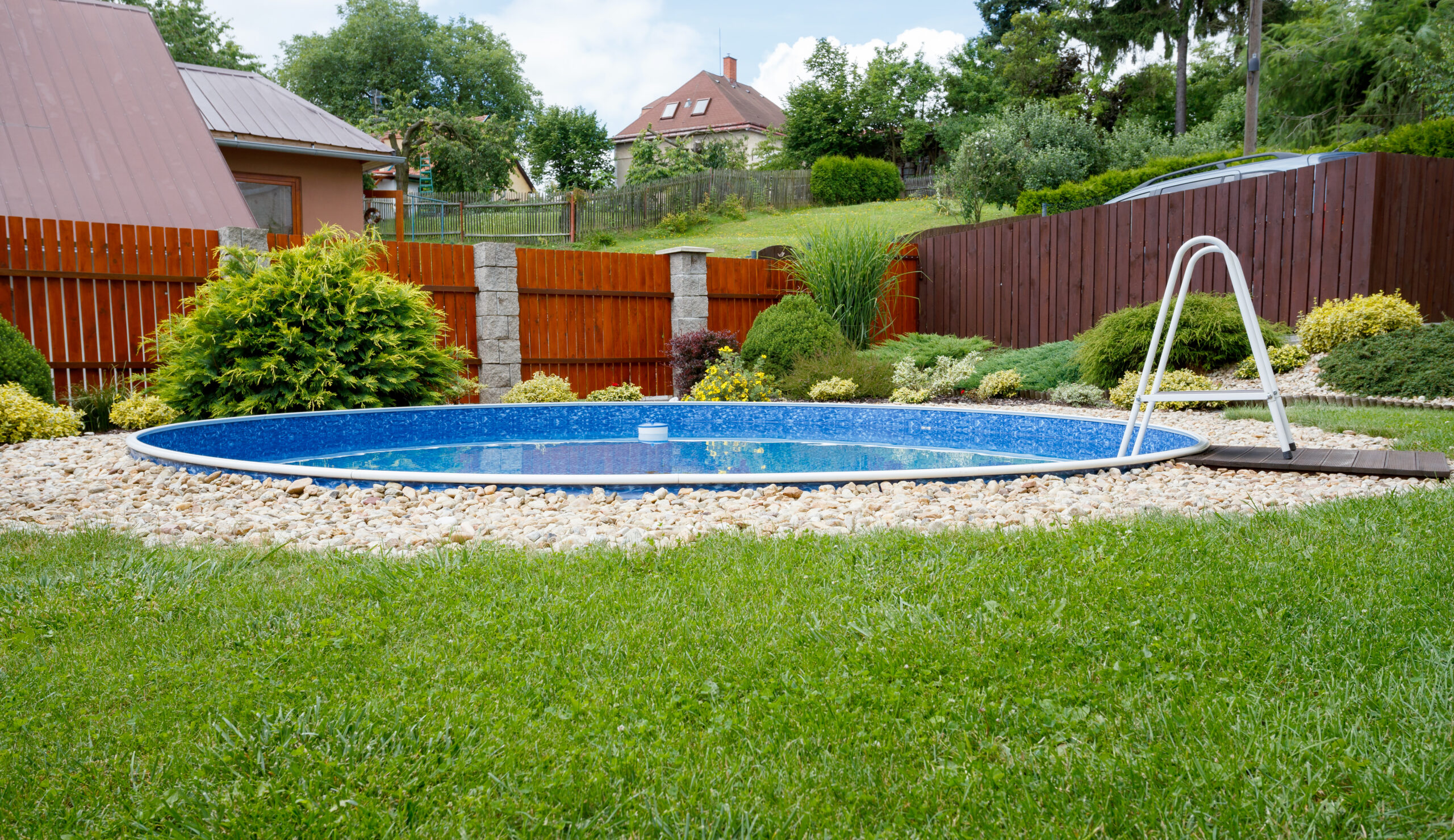 A pool surrounded by white rocks and green grass