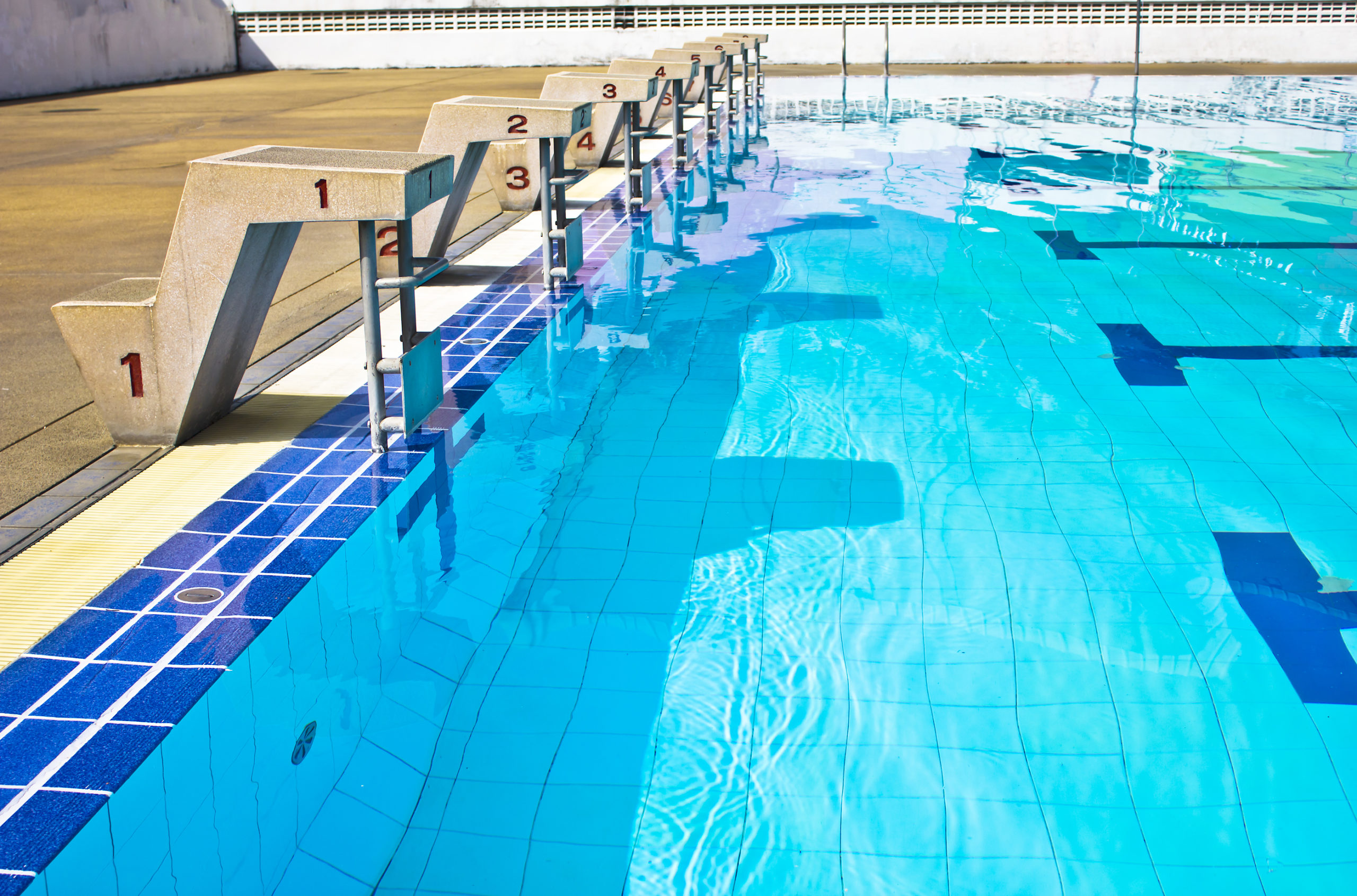 A competition pool with designated numbered lanes for swimmers.