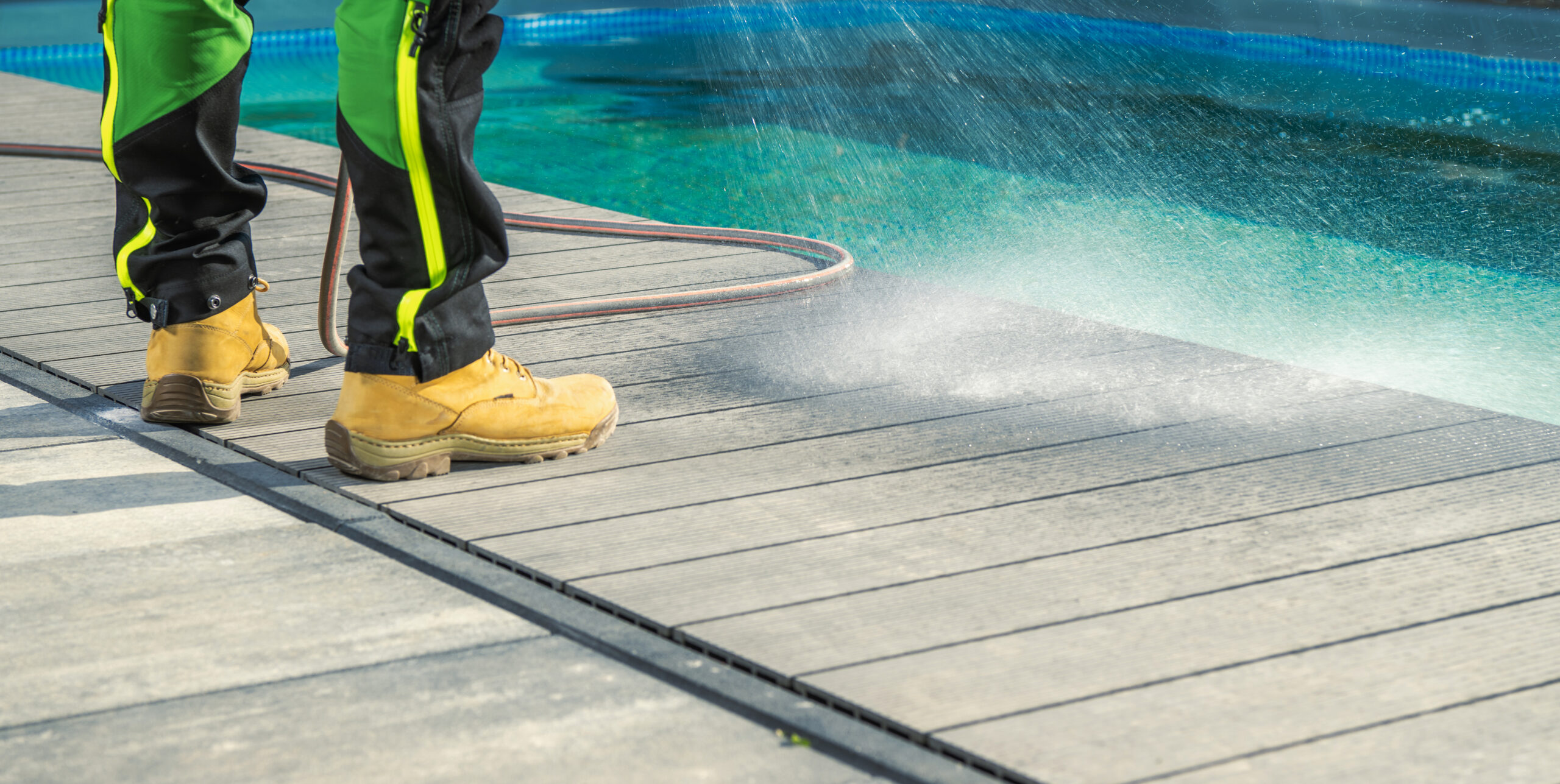 Cleaning a pool deck, demonstrating the process of maintaining and ensuring the cleanliness of the deck area surrounding the pool.