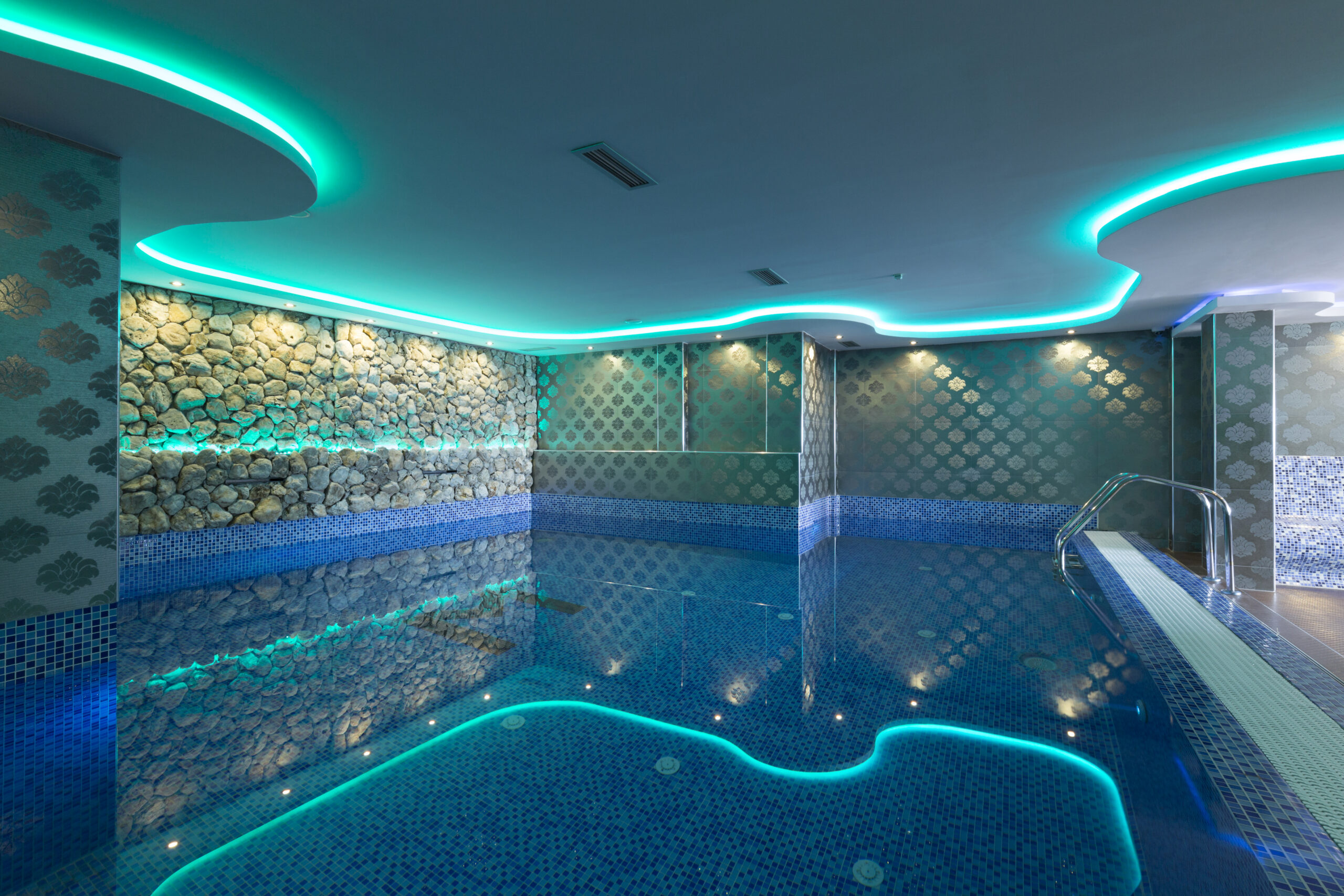 Indoor pool lighting design, showcasing various fixtures and arrangements that create an inviting and visually appealing atmosphere in an enclosed swimming area.