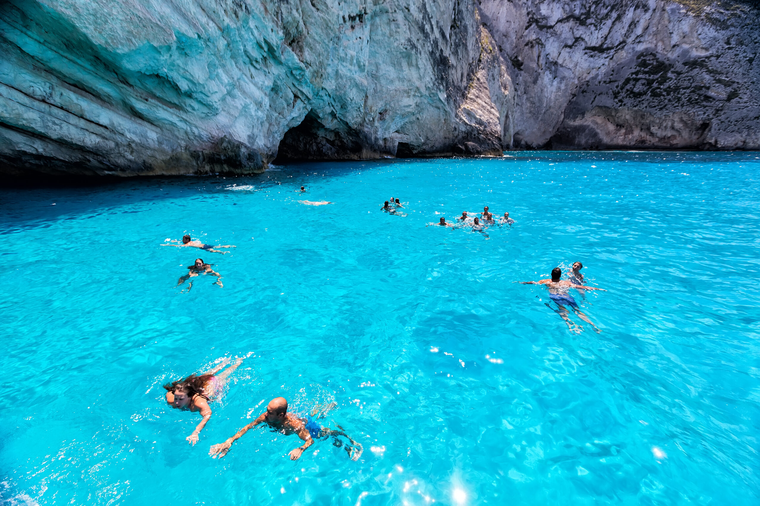 People happily enjoying a lagoon pool, with its serene and natural surroundings, offering a relaxing and idyllic aquatic experience